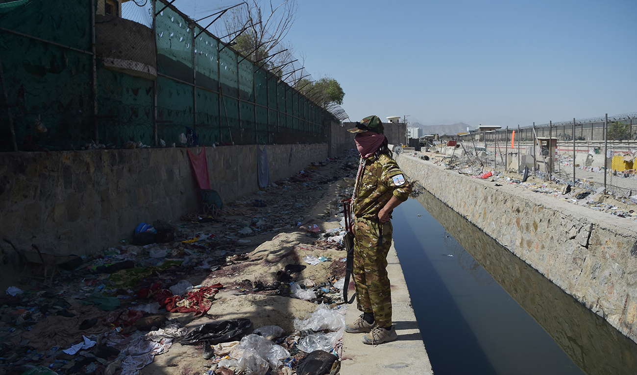 A Taliban fighter stands guard at the site of the August 26 twin suicide bombs, which killed scores of people including 13 US troops, at Kabul airport on August 27, 2021. (AFP/FILE)