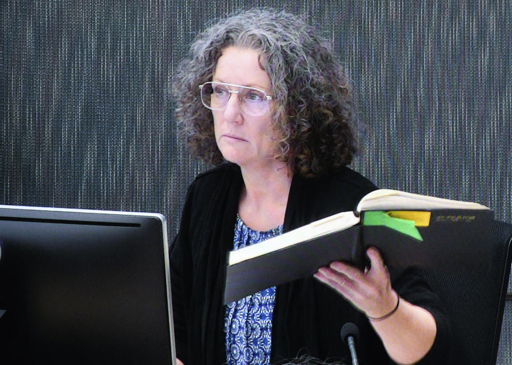 Kathleen Folbigg holds one of her diaries while appearing via video link screened at the New South Whales Coroners Court in Sydney, April 29, 2019. (Peter Rae/AAP Image via AP)