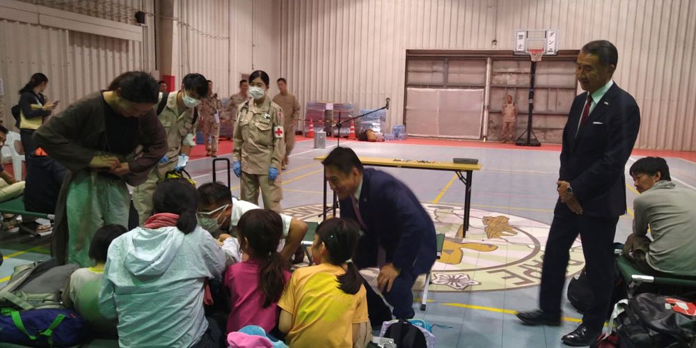 Deputy Foreign Minister Shunsuke Takei, center, meets evacuees from Sudan in Djibouti, Monday, April 24, 2023. (AP Photo)