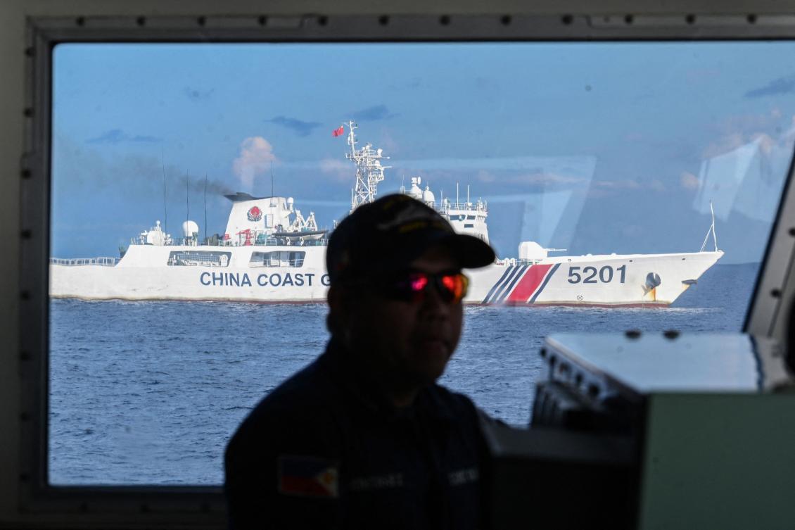 A member of the Philippine coast guard vessel BRP Malabrigo mans his post while being shadowed by a Chinese coast guard ship at Second Thomas Shoal in the Spratly Islands in the disputed South China Sea. (AFP)