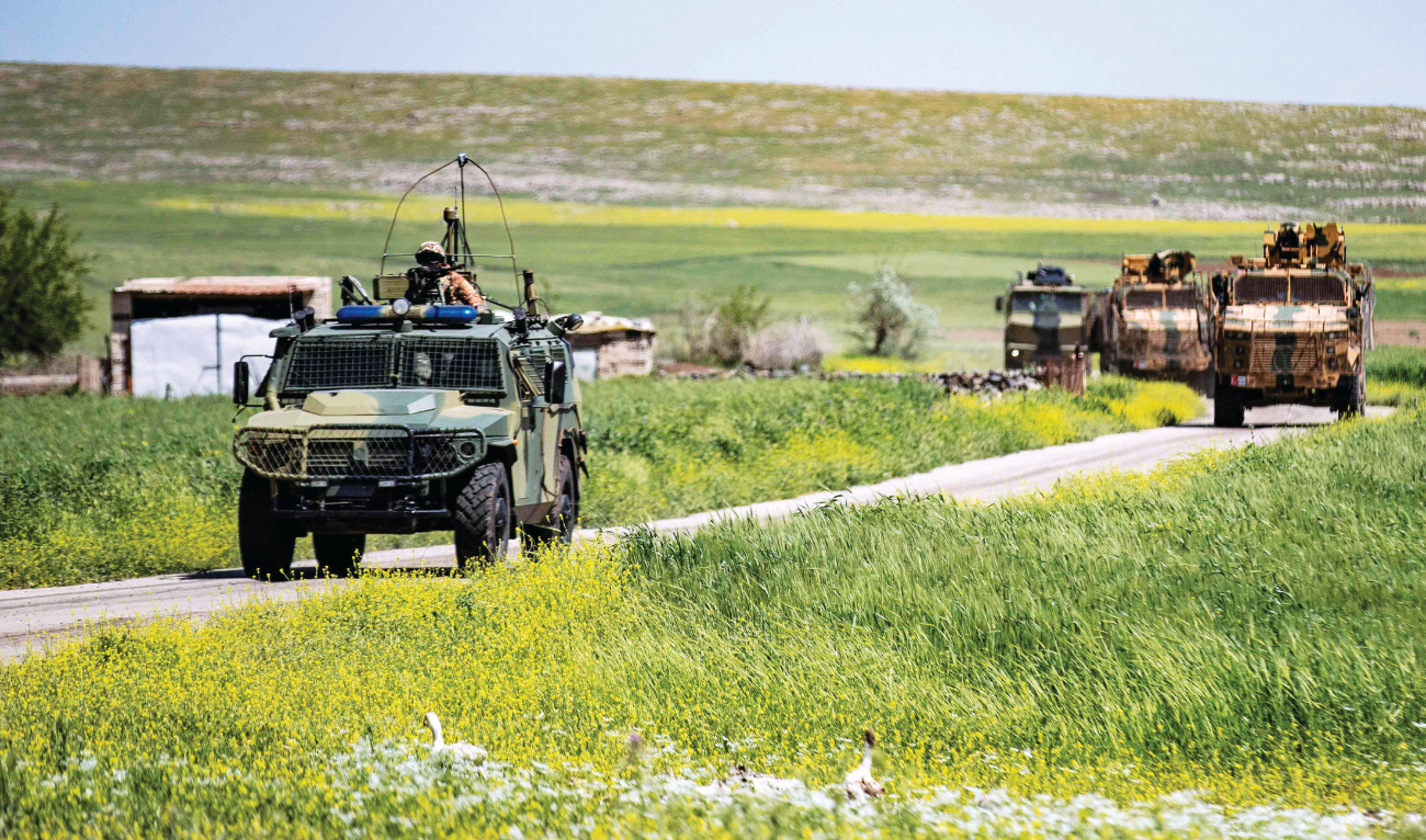 Turkish and Russian military vehicles patrol in the countryside of Rumaylan in Syria’s northeastern Hasakeh province bordering Turkiye on Thursday. (AFP)