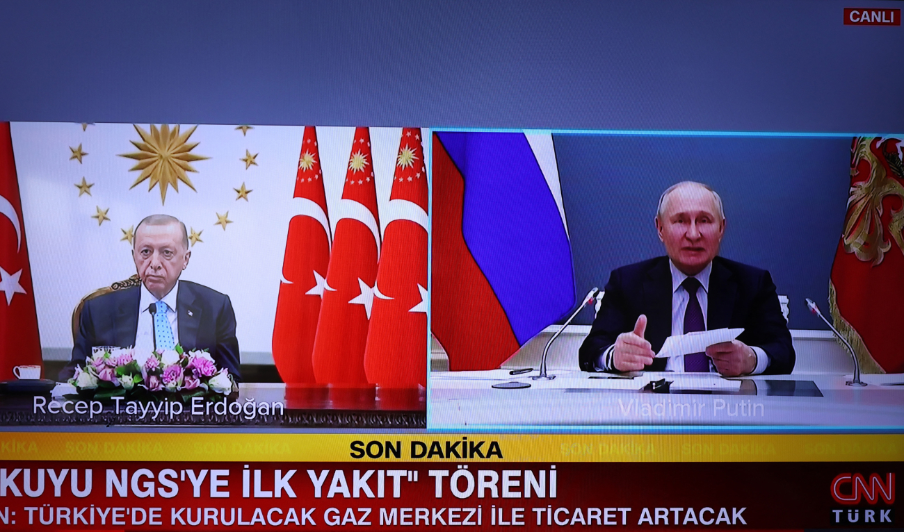 A screen in Ankara broadcasting the live feed of TV channel CNN Turk, showing Turkish President Recep Tayyip Erdogan (L) and Russian President Vladimir Putin (R) speaking over video link, for the opening of Akkuyu Nuclear Power Plant held in Mersin on April 27, 2023. (AFP)