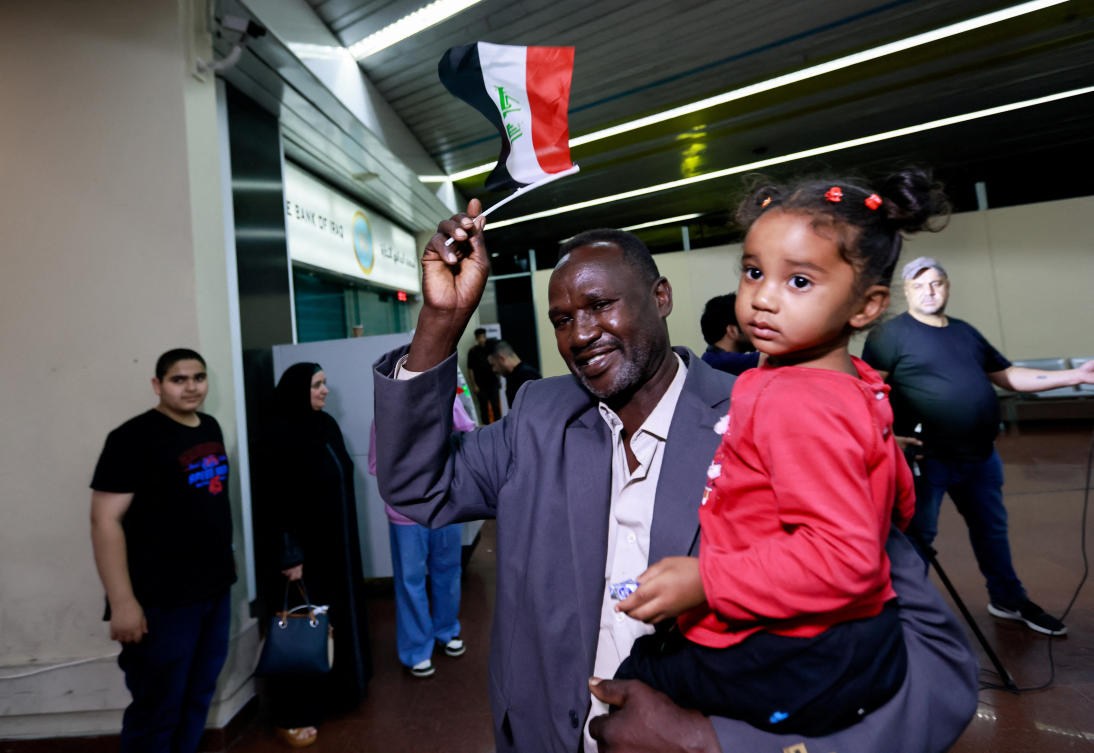 Iraqis and Syrians who were evacuated from Sudan by Iraqi military aircraft, arrive at Baghdad International Airport in Baghdad, Iraq. (Reuters)
