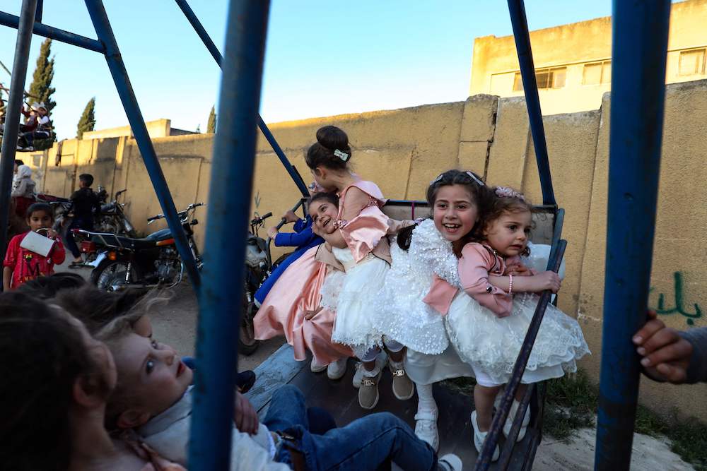 Children ride a swing in the rebel-held town of Maaret Misrin in Syria’s northwestern Idlib province, on April 21, 2023. (AFP)