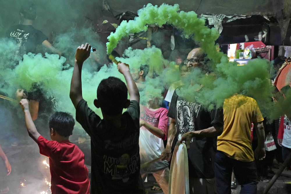 Youths light smoke sticks during the celebration of the eve of Eid Al-Fitr on a street in Jakarta, Indonesia, Friday, April 21, 2023. (AP)