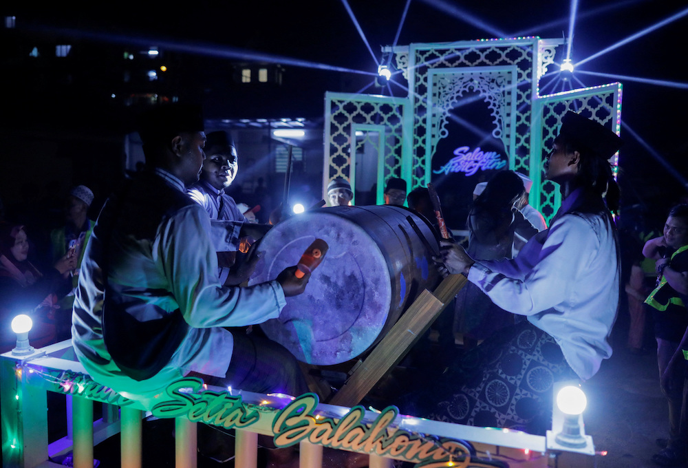 Muslims sing religious songs while they parade around their residential area as they celebrate the Eid Al-Fitr at Balakong, Malaysia. (Reuters)