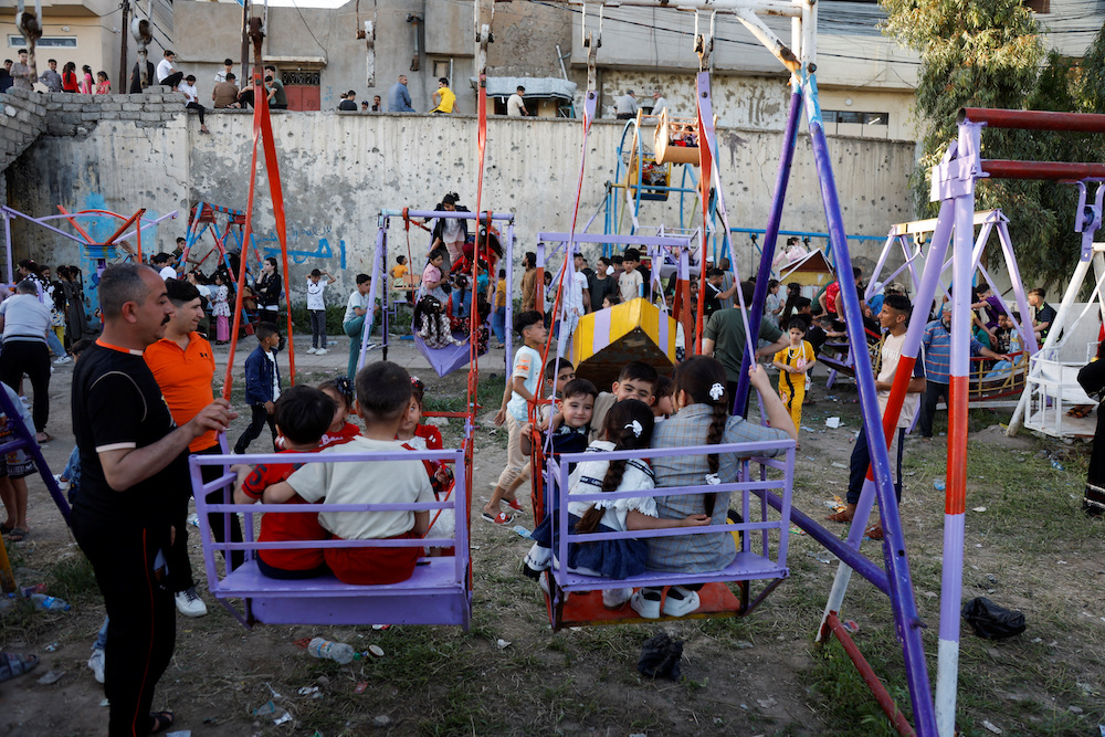 Iraqi children play as they celebrate Eid Al-Fitr, in Mosul, Iraq April 21, 2023. (Reuters)