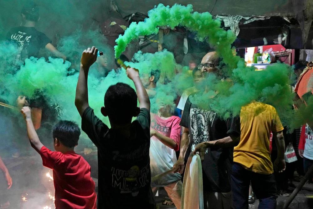 Youths light smoke sticks during the celebration of the eve of Eid Al-Fitr on a street in Jakarta, Indonesia, Friday, April 21, 2023. (AP)