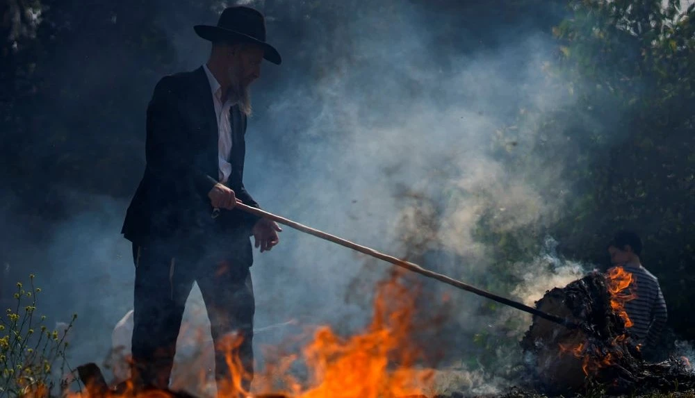An ultra-Orthodox Jewish man burns leavened items in preparation for Passover, Bnei Brak, Israel, Apr. 5, 2023. (AP Photo)