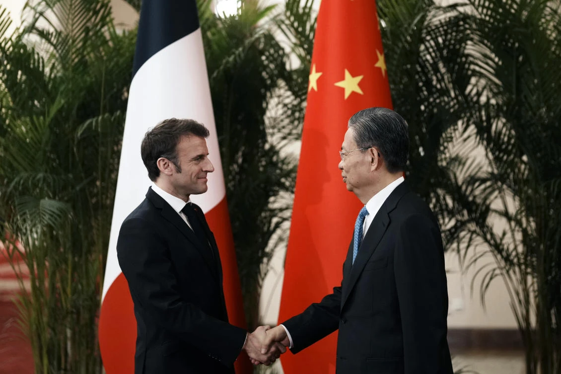 France’s President Emmanuel Macron shakes hand with the head of China’s National People’s Congress Zhao Leji prior to a meeting at the Great Hall of the People in Beijing on April 6, 2023. (AP)