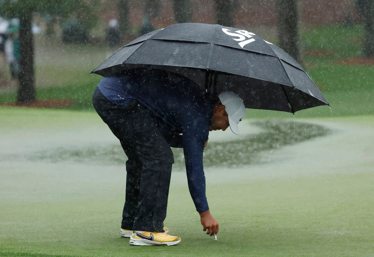 Brooks Koepka of the US marks his ball position on the 7th hole green as play is suspended due to inclement weather conditions during the third round of the Masters golf tournament at Augusta National Golf Club. (Reuters)