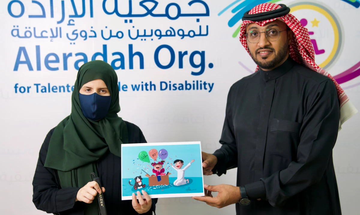 Visually impaired artist Amjad Al-Mutairi and Atef Almatari, PR manager at Aleradah organization, launch the special edition Amazon.sa Eid eGift card.