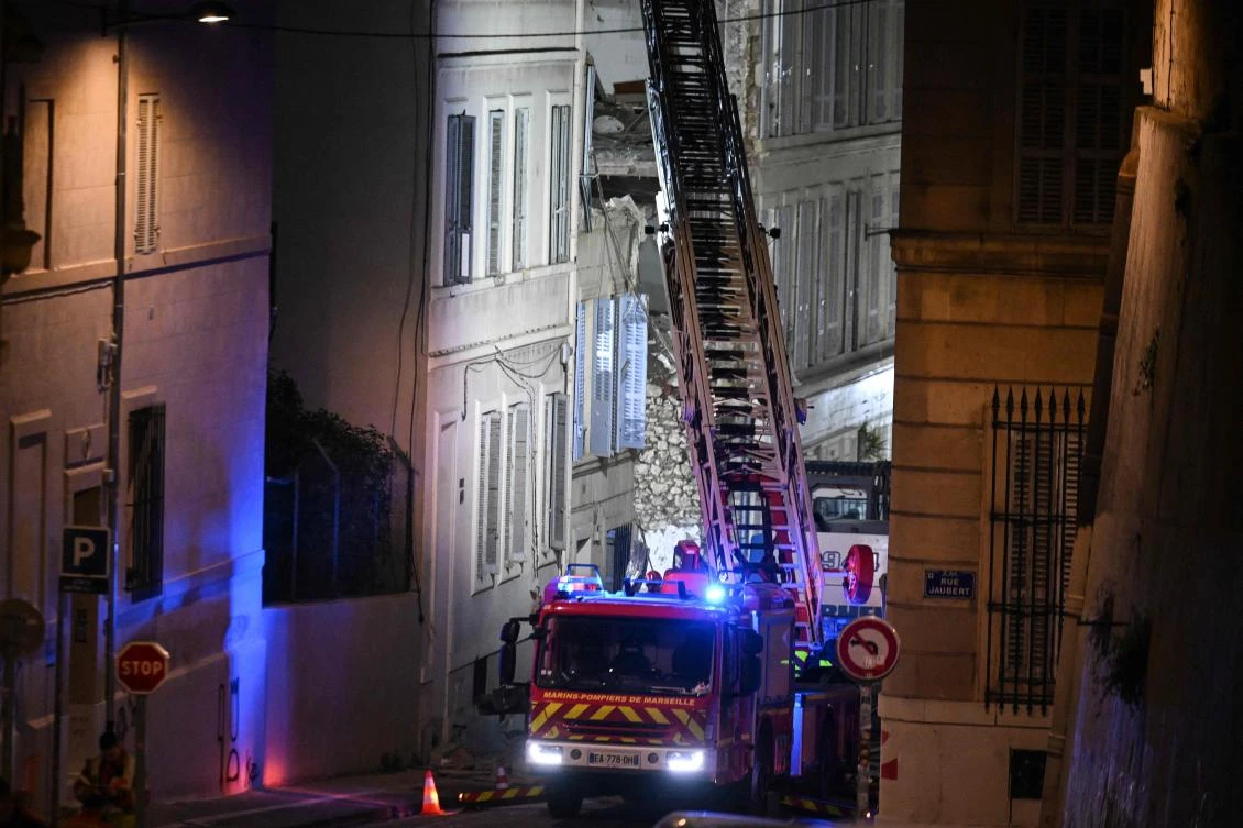 A firetruck extends a ladder at the scene of a collapsed building on 'rue Tivoli', in Marseille, southern France, on April 10, 2023. (AFP)