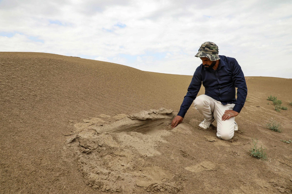 In this picture taken on March 31, 2023, Archaeologist Aqeel Mansarawi searches for the remains of an ancient structure at the Umm al-Aqarib archaeological site in the district of al-Rifai in Iraq's southern Dhi Qar province. (Asaad Niazi/AFP)