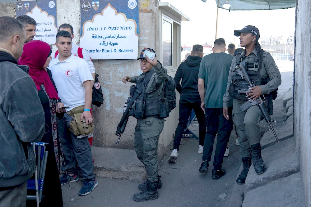 Israeli border police officers check identification cards of Palestinians while they try to cross from the occupied West Bank into Jerusalem to pray during the holiest night of Ramadan on April 17, 2023. (AP)