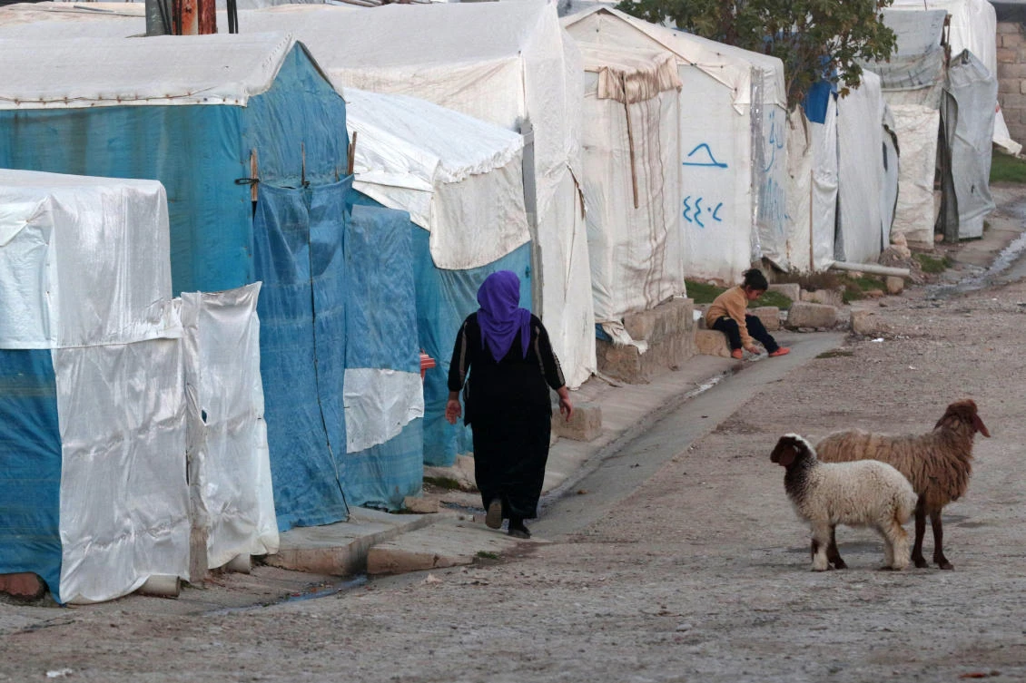 A displaced Iraqi woman walks in front of tents at a camp for internally displaced persons in Khanke. (File/AFP)
