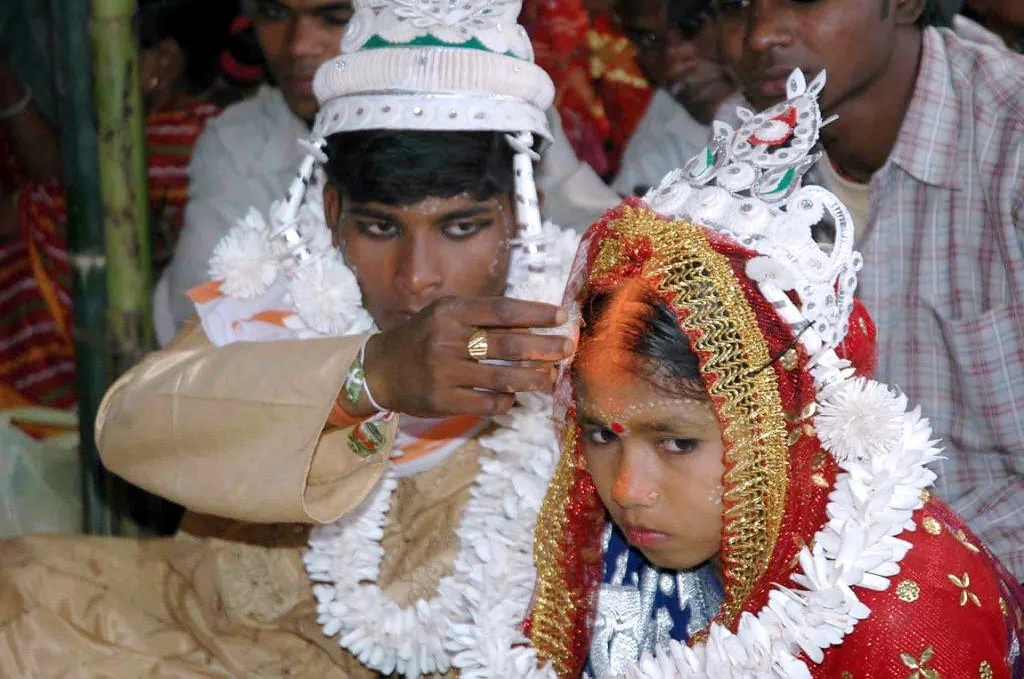 An Indian groom puts vermilion on the forehead of his underage bride in the village of Malda, some 360kms northeast of Kolkata in this file photo. (AFP)