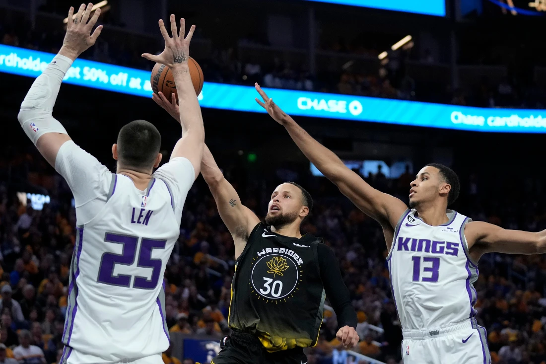Golden State Warriors guard Stephen Curry scores against Sacramento Kings center Alex Len (25) and forward Keegan Murray (13) during the second half of Game 3 of an NBA basketball first-round playoff series in San Francisco. (AP)