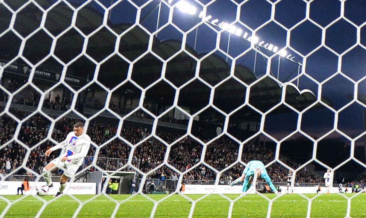 Paris Saint-Germain's French forward Kylian Mbappe (L) shoots and scores his team's second goal against Angers' French goalkeeper Paul Bernardoni during their French L1 football match at The Raymond-Kopa Stadium in Angers, western France on Friday. (AFP)