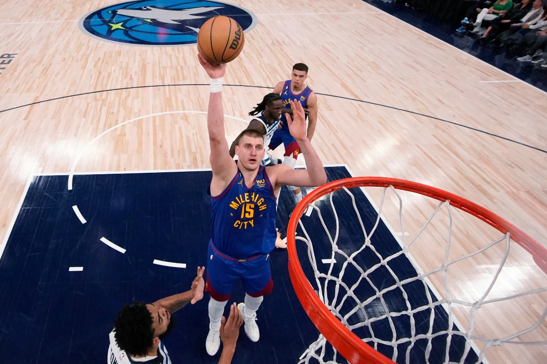 Denver Nuggets center Nikola Jokic (15) shoots next Minnesota Timberwolves' Karl-Anthony Towns, left, during the first half of Game 3 of an NBA basketball first-round playoff series in Minneapolis. (AP)