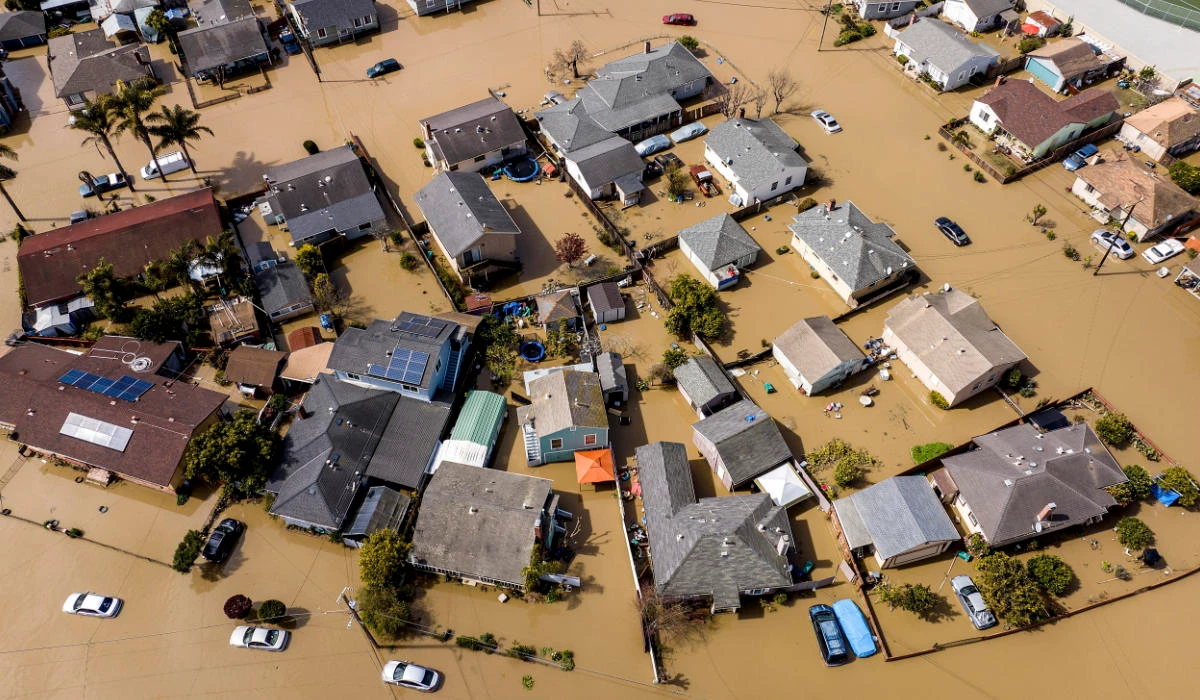 Floodwaters surround homes and vehicles in Monterey County, California.