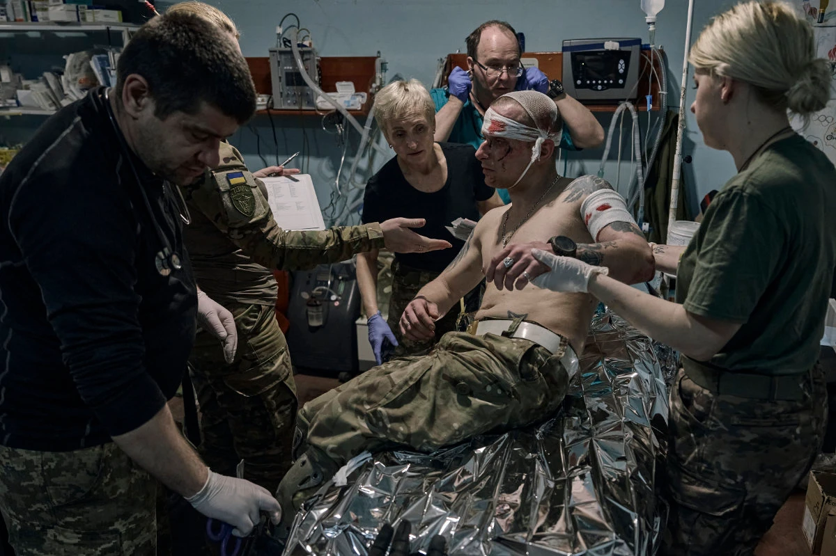 Medics give first aid to a wounded Ukrainian soldier at a medical stabilization point near Bakhmut, Donetsk region, on April 27, 2023. (AP Photo/Libkos)