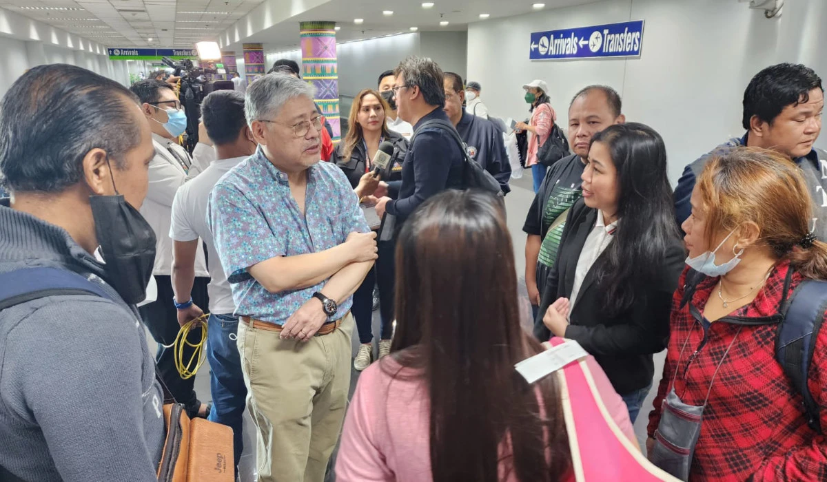 Foreign Affairs Secretary Enrique Manalo receives the first batch of Filipino evacuees from Sudan at Manila airport on Saturday. (Philippine Department of Foreign)