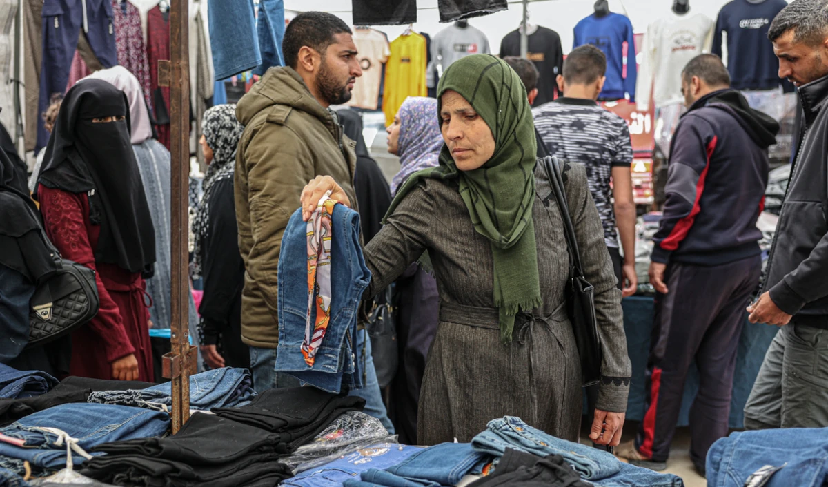 A Palestinian woman looks at garments at a clothing shop in a Gaza City market. Hikes in import and export tariffs have fueled discontent among merchants. (AFP)
