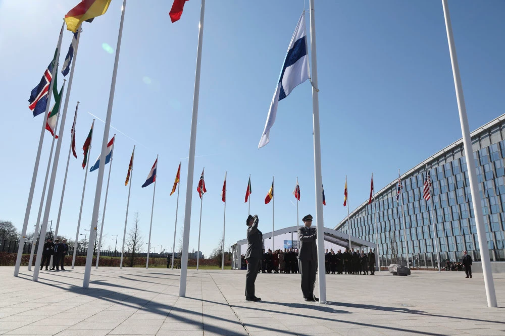 Military personnel raise the flag of Finland during a flag raising ceremony on the sidelines of a NATO meeting in Brussels. (AP)