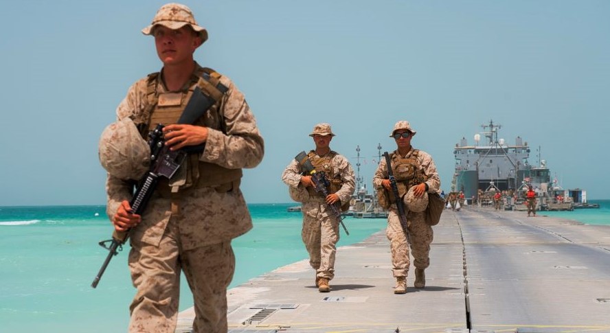 US Marines on a removable pier leading to a ship docked near an Emirati naval base in Al-Hamra, RAK, Mar. 23, 2020. (AP Photo)