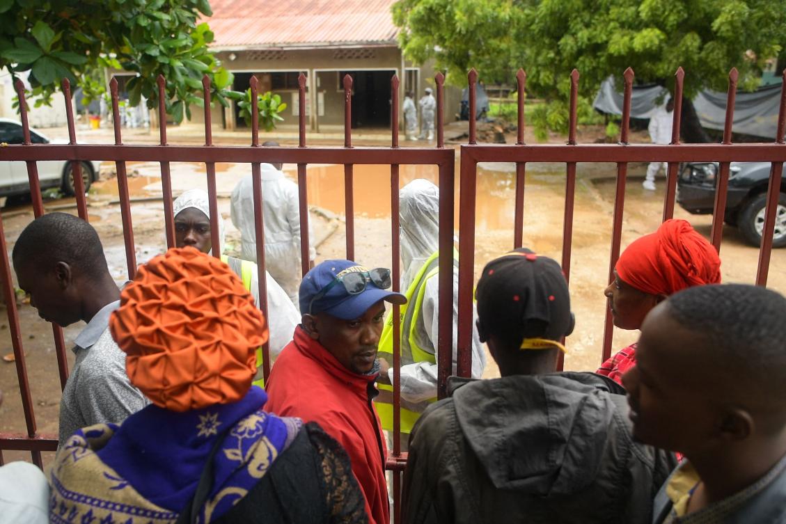 Friends and relatives of victims stand outside the gates of a funeral home at the Malindi district in Kenya as autopsies begin on more than 100 bodies linked to a religious cult. (AFP)