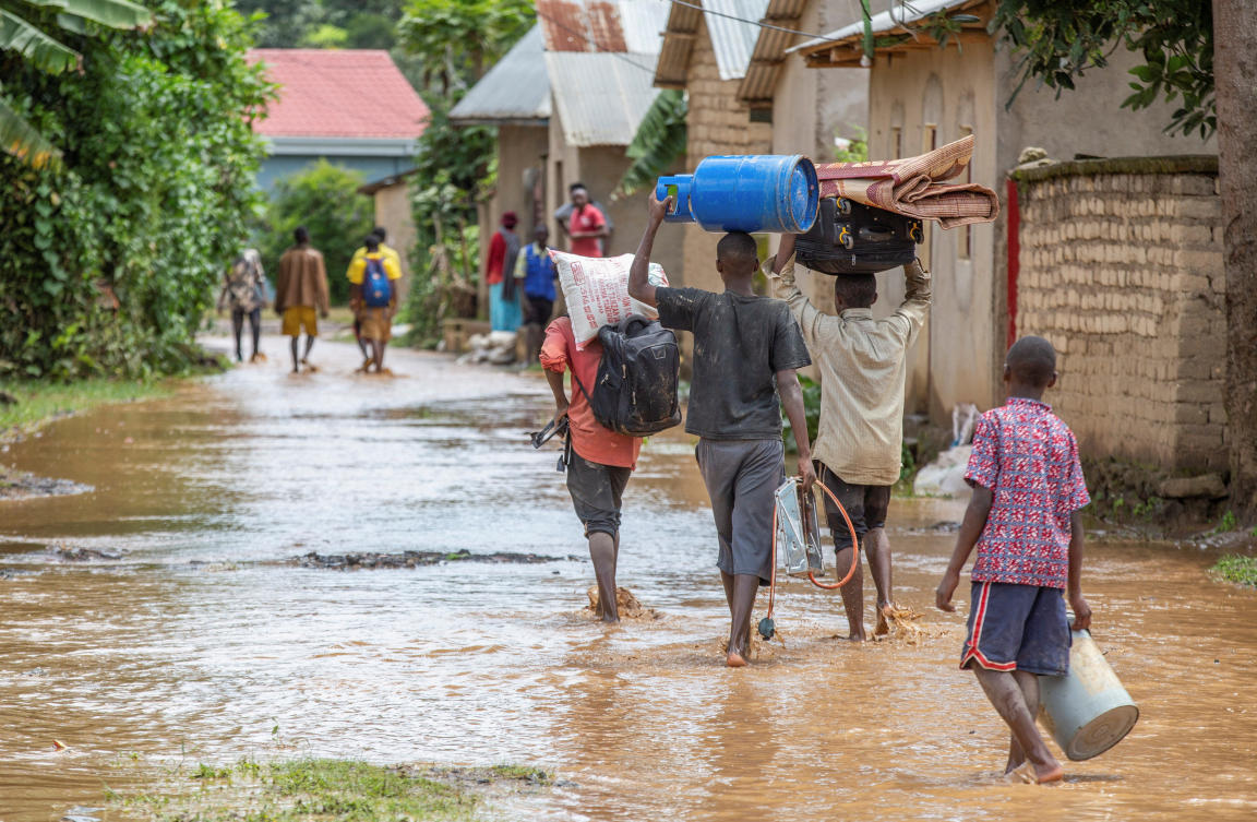 Residents wade through water after their homes were swamped following rains that triggered flooding and landslides in Rwanda. (Reuters)