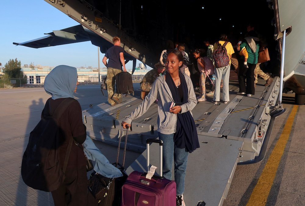 Sudanese citizens with UK citizenship wait to board a British military aircraft before being processed for evacuation in Port Sudan on May 3, 2023. (Reuters)