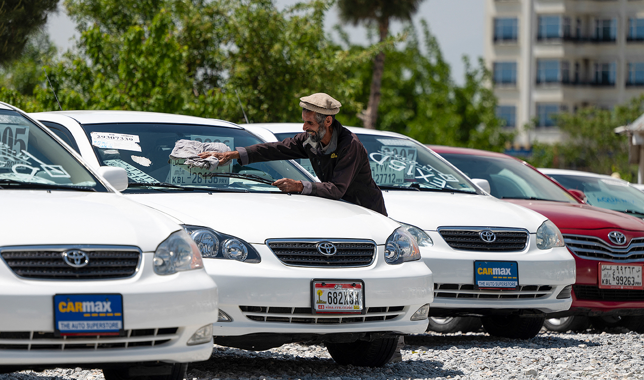 In this photograph taken on April 25, 2023, an Afghan worker cleans a Toyota Corolla car parked at a dealership in Qasaba in Kabul. (Photo courtesy: AFP)