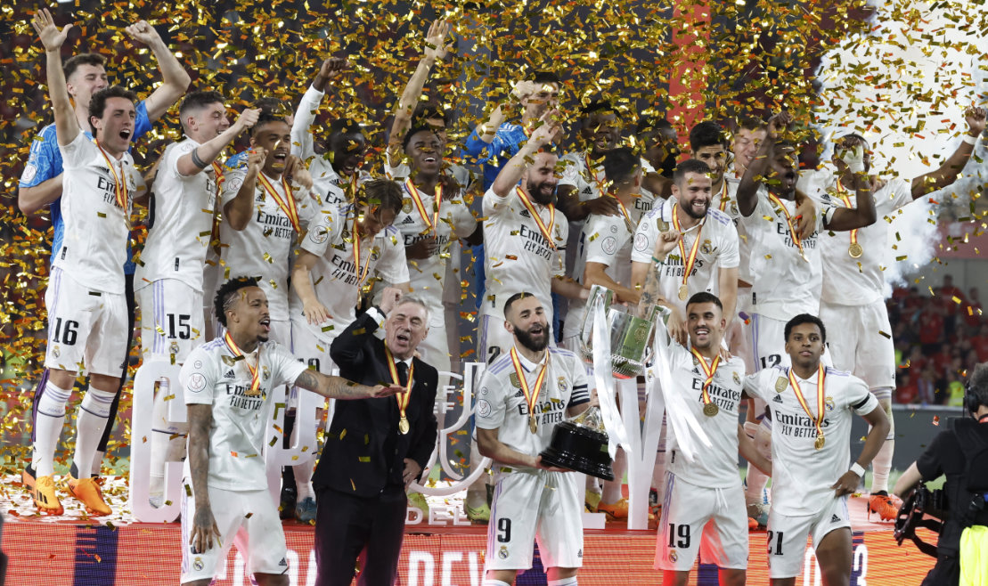 Real Madrid's Karim Benzema celebrates with the trophy and teammates after winning the Copa del Rey final against Osasuna at La Cartuja stadium in Seville on Saturday. (Reuters)
