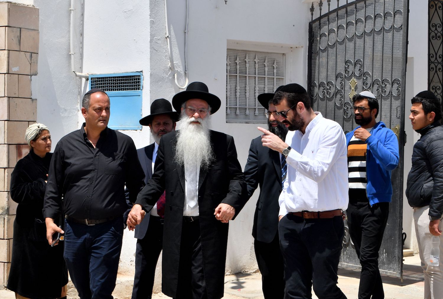 Members of the Jewish community leave a yeshiva (Talmudic school) with a raabi in the Hara Kebira, the main Jewish quarter of the resort island of Djerba, near the Ghriba synagogue. (AFP)