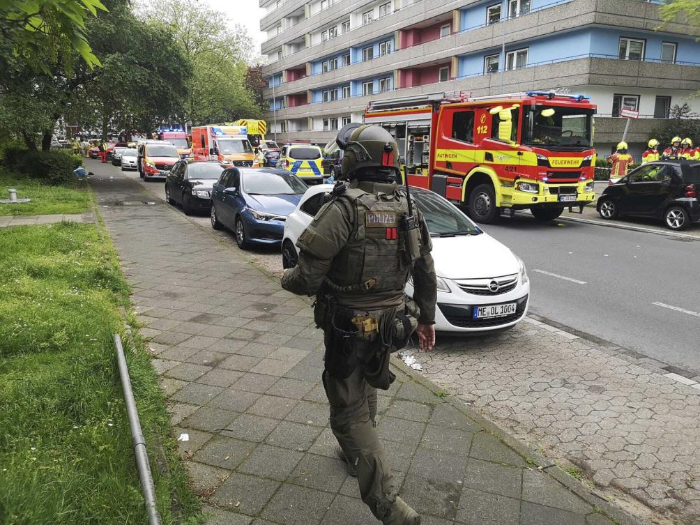 Police officers and firefighters stand in front of a residential building in Ratingen, Germany, on May 11, 2023. (AP)