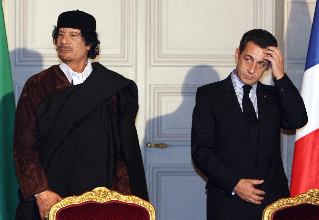 French President Nicolas Sarkozy and Libyan leader Muammar Qaddafi pose during the signature of 10 billion euros of trade contracts between the two countries, at the Elysee Palace in Paris on Dec. 10, 2007. (AFP/File)