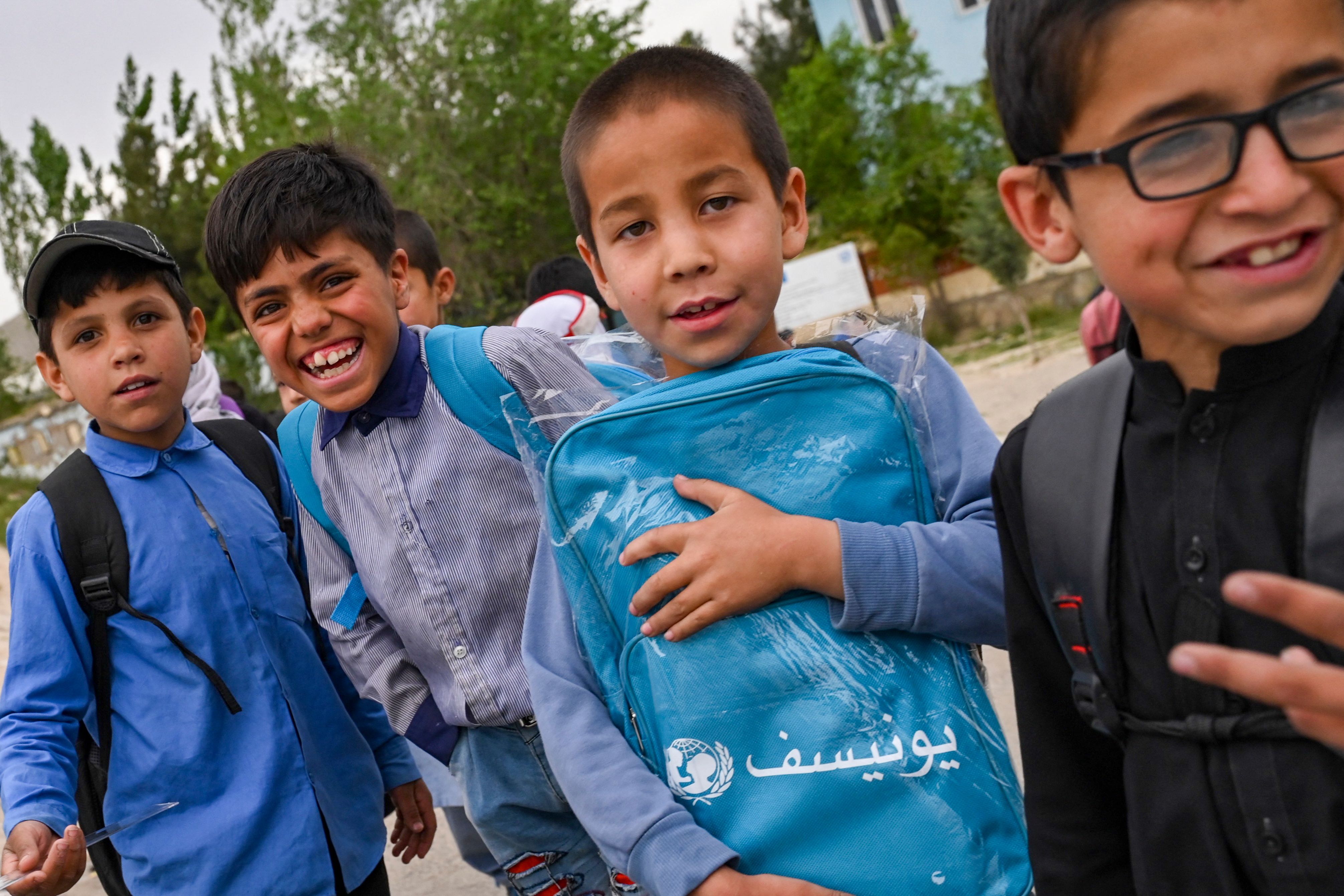 Afghan boys gesture as they walk along a street on the outskirts of Kabul on May 11, 2023. (AFP)