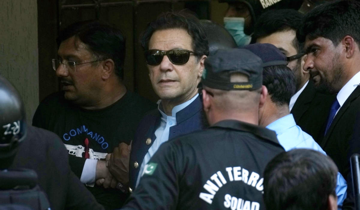 Pakistan's former Prime Minister Imran Khan, center, is escorted by police officers as he arrives to appear in a court, in Islamabad, Pakistan, Friday, May 12, 2023. (AP)