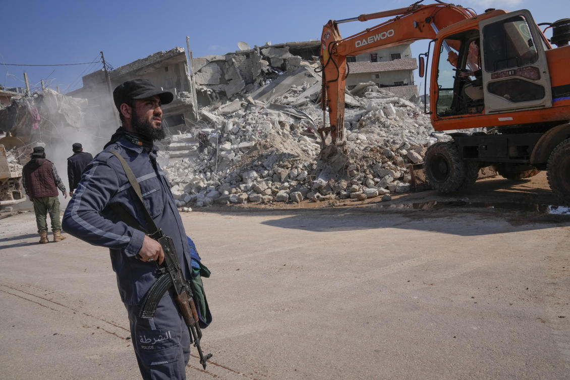 An al-Qaida-linked Hayat Tahrir al-Sham militant stands in front of a destroyed house in Atareb, Syria, Sunday, Feb. 12, 2023. (File/AP)