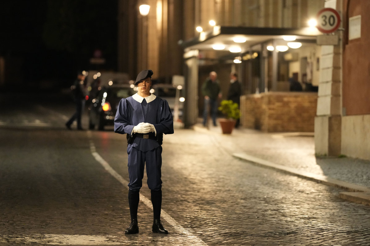 A Swiss Guard officer patrols the Santa Anna gate at the Vatican late Thursday. (AP)