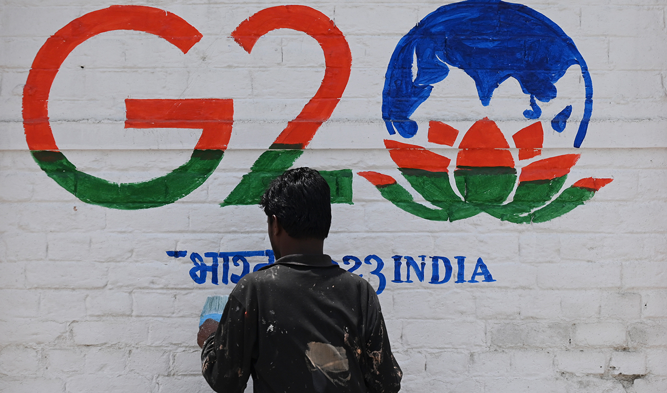 A man paint a wall with the logo of India's G20 summit in Srinagar on May 16, 2022. (AFP/File)