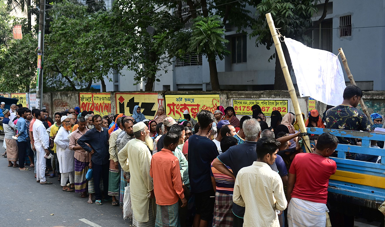 People wait in queue to buy food at subsidised price fixed by the government in Dhaka on November 17, 2022. (Photo courtesy: AFP)