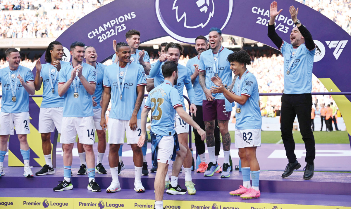 Manchester City’s Spanish manager Pep Guardiola, right, and his players gather on the podium at the Premier League presentation ceremony following the English Premier League football match between Manchester City and Chelsea at the Etihad Stadium in Manchester, northwest England, on Sunday. (AFP)
