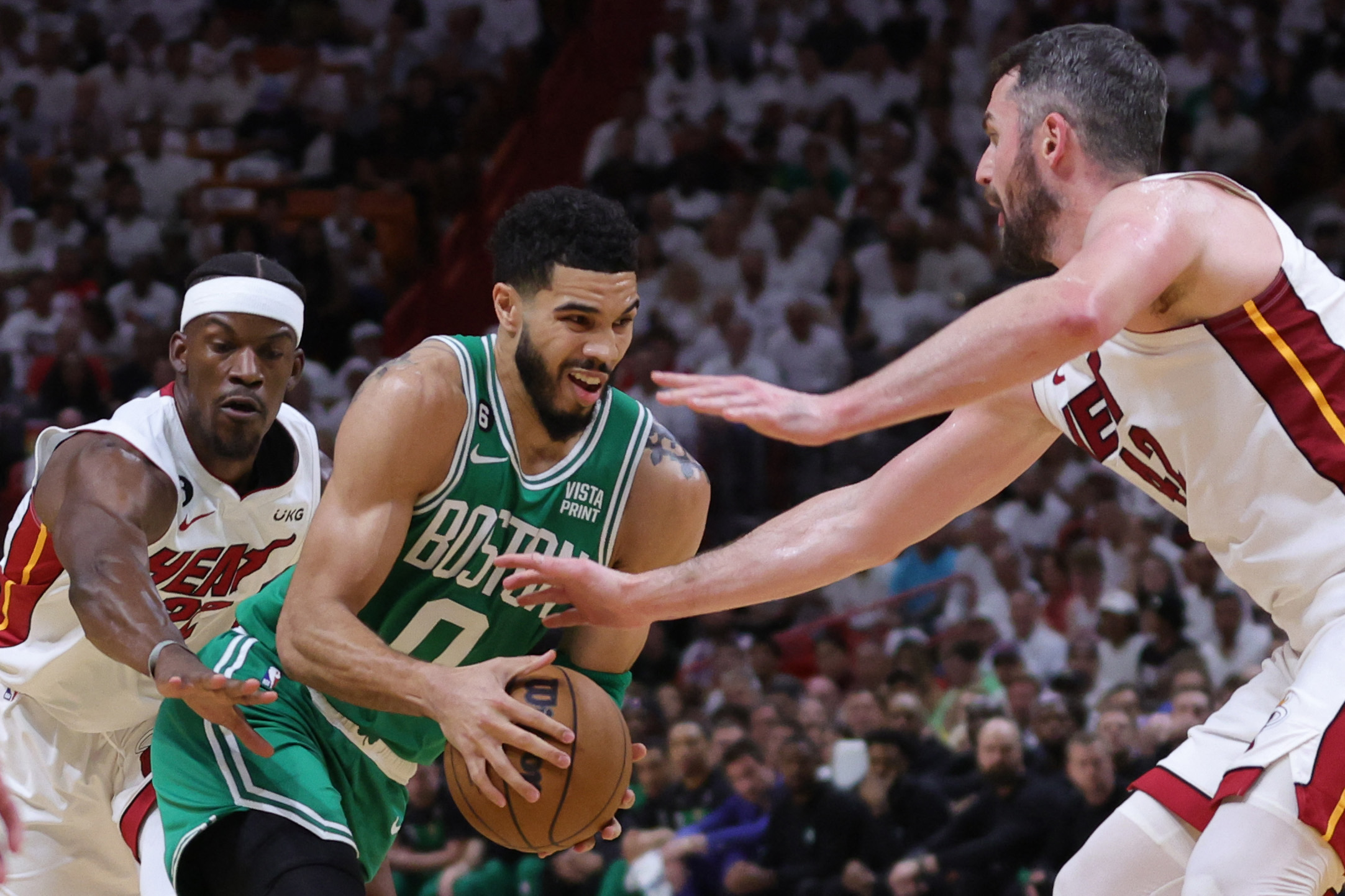 Jayson Tatumof the Boston Celtics drives through Jimmy Butler and Kevin Love of the Miami Heat during the first quarter in Game 4 of the Eastern Conference Finals at Kaseya Center. (AFP)