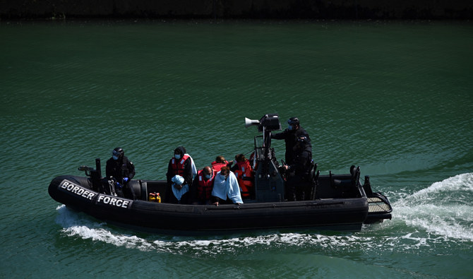 Migrants are seen on the UK Border Force rubber dinghy, after they were picked up at sea while attempting to cross the English Channel, and brought to the Marina in Dover, southeast England, on June 16, 2022. (AFP/File)