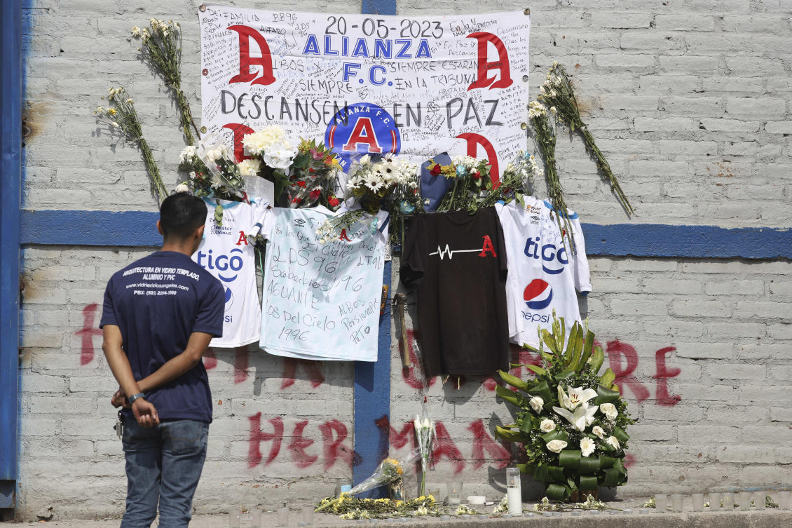 A fan of Alianza FC looks at a memorial set up as a tribute to the soccer fans killed in the recent Cuzcatlan stadium stampede, outside the stadium in San Salvador on May 22, 2023. (AP)