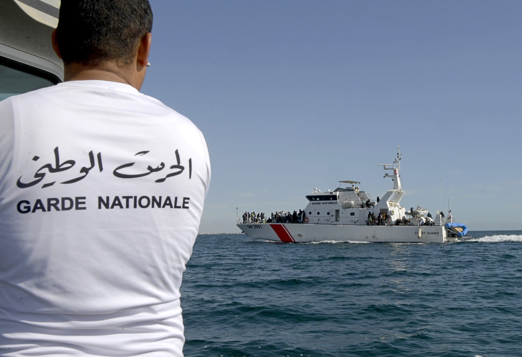 A file of migrants from sub-Saharan Africa are rescued by the Tunisian National Guard off their makeshift boats which were used to make their way to the Italian coast, about 50 nautical miles in the Mediterranean sea off the coast of the central Tunisian city of Sfax (AFP)