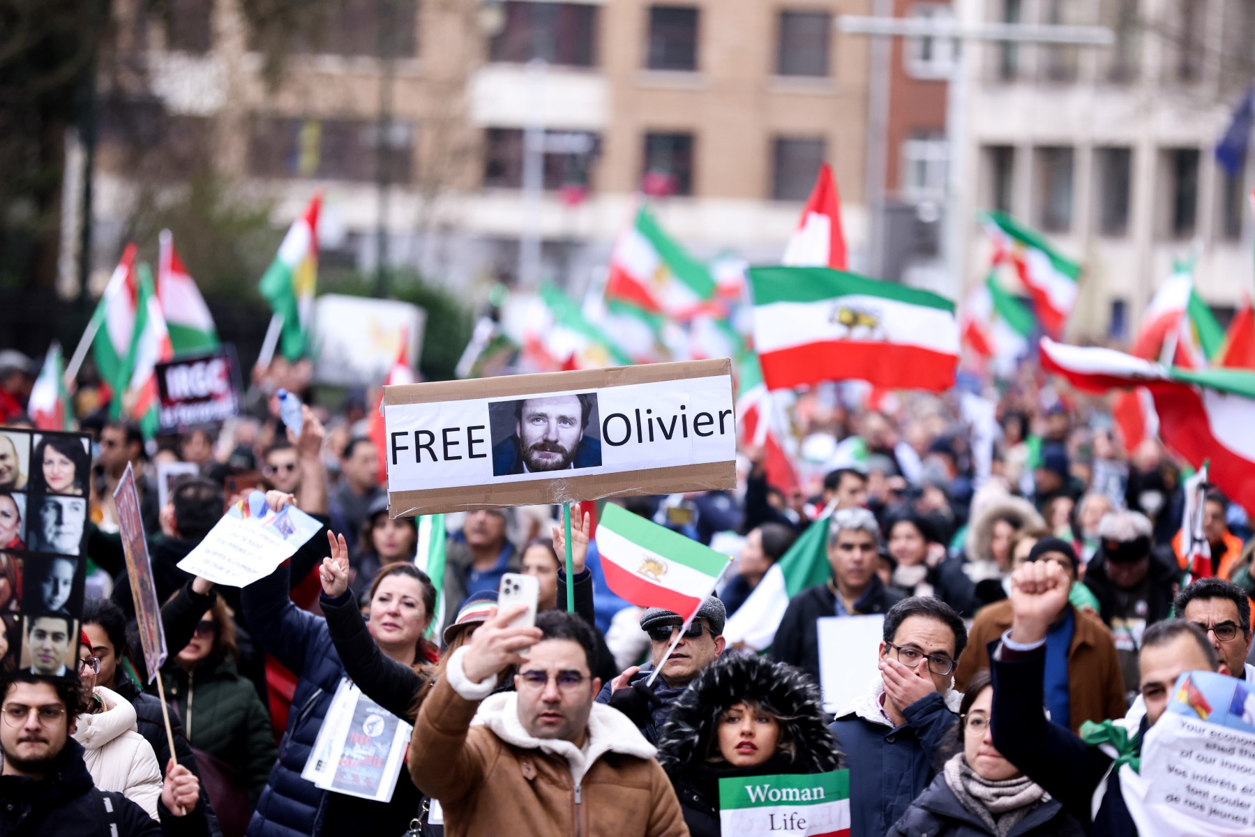 Demonstrators hold placards with the portrait of detained Belgian aid worker Olivier Vandecasteele, as they take part during a protest supporting Iranian resistance movement in Brussels. (AFP)
